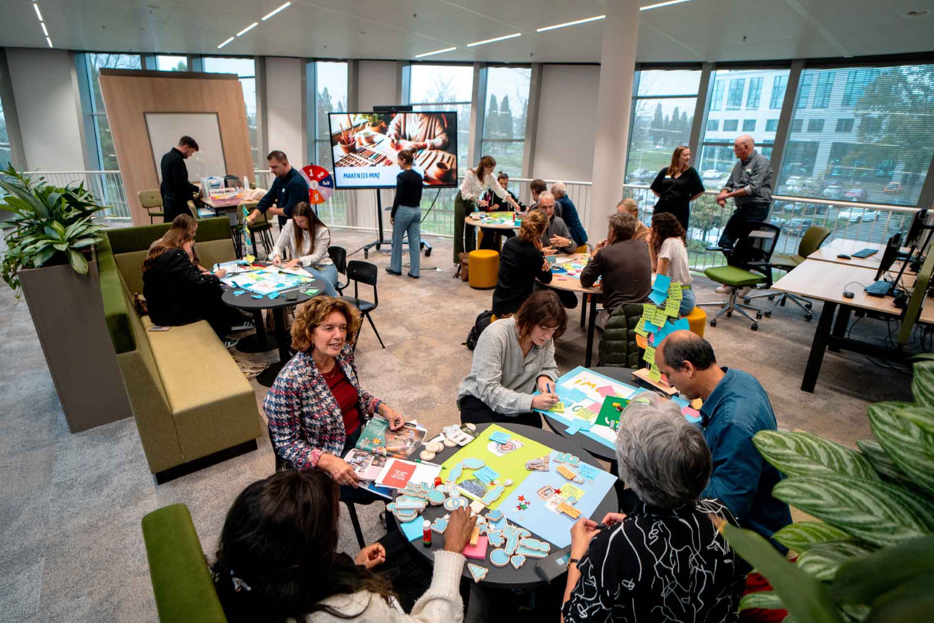 Mensen werken in groepen aan een opdracht voor het gezondheid innovatie atelier bij Avans