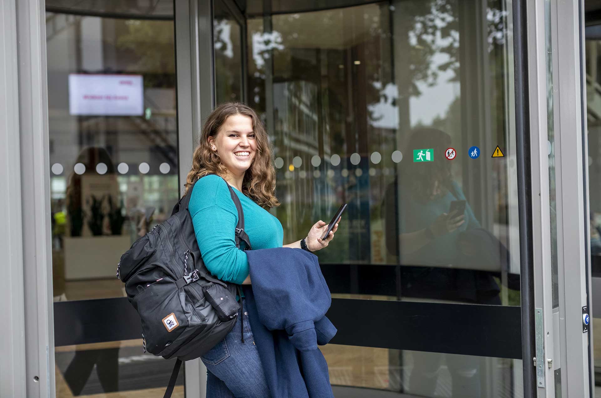 Avans student bij de ingang van de hogeschool